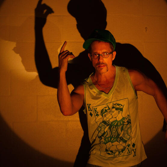 sirdanpaul pointing up beside his shadow in a golden spotlight, photo by Taylor Cullen